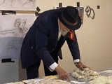 Markus Lüpertz prüft zum Beginn seines Maleinsatzes die Stärke des Farbglasurauftrages aus der Arbeit des Vortages. Man erkennt die starke Modellierung des archaischen Kunstwerkes aus riesigen und bis zu 150 kg schweren Keramikplatten, Foto: Fabry